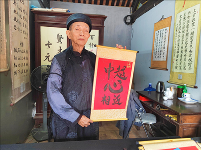 越南首都河內(nèi)文廟內(nèi)，阮明珠展示“中越心相近”書法作品。