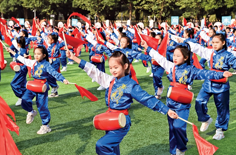 為助推民族地區(qū)基礎(chǔ)教育事業(yè)發(fā)展，廣西重新核定各地中小學(xué)教職工編制，依托全區(qū)編制“周轉(zhuǎn)池”核增事業(yè)編制給各地中小學(xué)，在全面達(dá)到國(guó)家標(biāo)準(zhǔn)的基礎(chǔ)上，進(jìn)一步統(tǒng)籌優(yōu)化和動(dòng)態(tài)調(diào)整各區(qū)域、學(xué)校、學(xué)段間編制資源。圖為2023年11月29日，南寧市濱湖路小學(xué)舉行主題為“逐夢(mèng)新時(shí)代 健體向未來”的體育文化節(jié)，孩子們正在跳腰鼓舞。 新華社記者 周華/攝