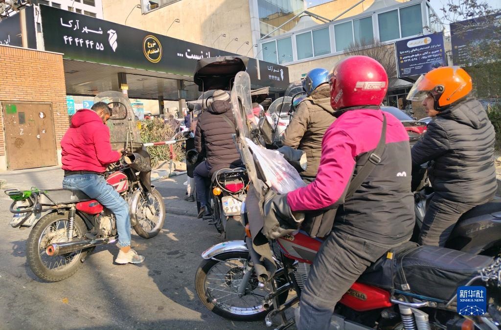 12月18日，摩托車在伊朗首都德黑蘭的一家加油站外等待加油。新華社記者 沙達(dá)提 攝