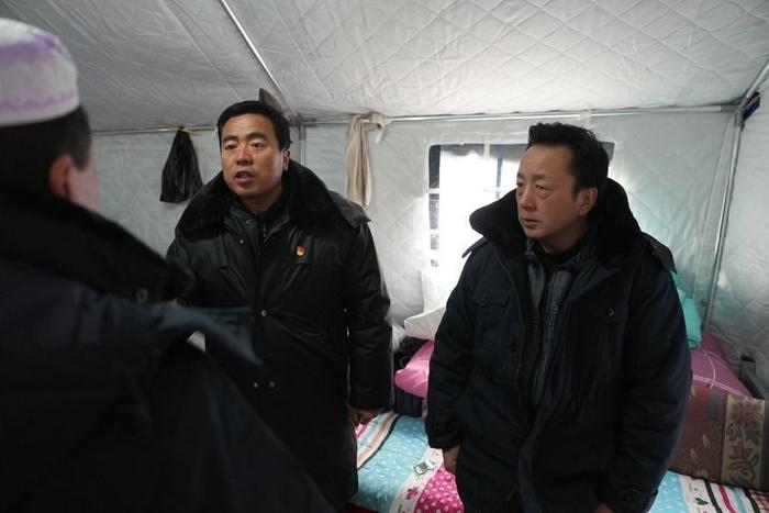 2023年12月22日，積石山縣大河家鎮(zhèn)大河村黨支部書記馬成忠（右二）在帳篷里和受災(zāi)群眾交流。新華社記者 陳斌 攝