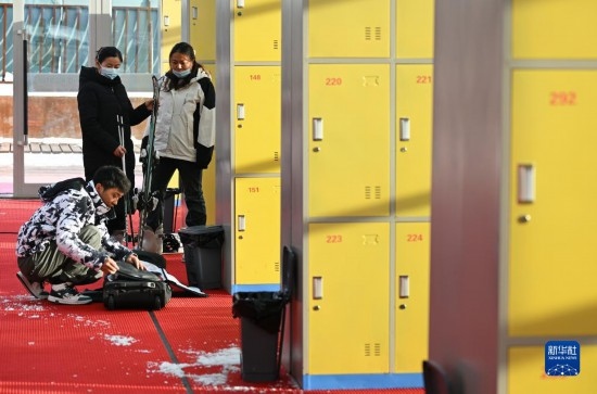 12月21日，游客在滑雪服務(wù)大廳整理滑雪裝備。