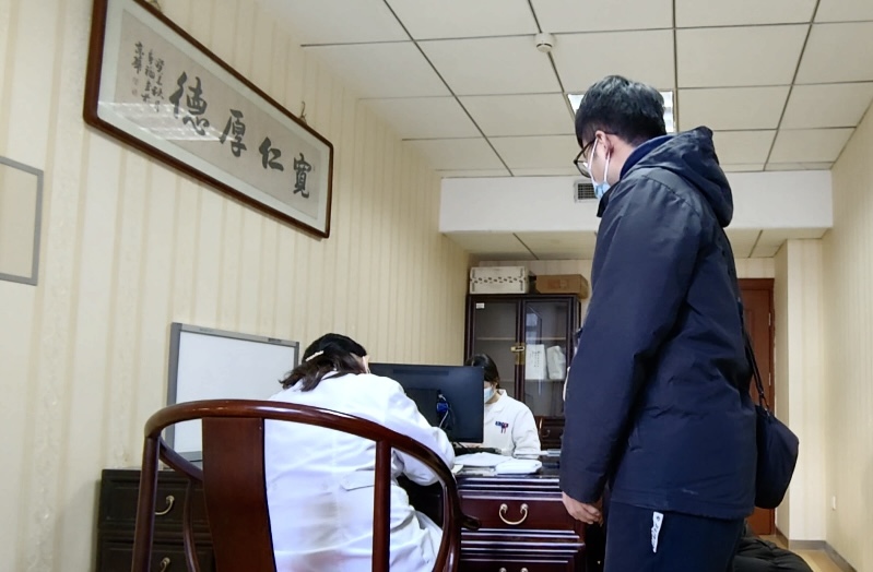 陪診師大飛陪同來(lái)京就診的患者在醫(yī)院?jiǎn)栐\。人民網(wǎng)記者 任妍攝