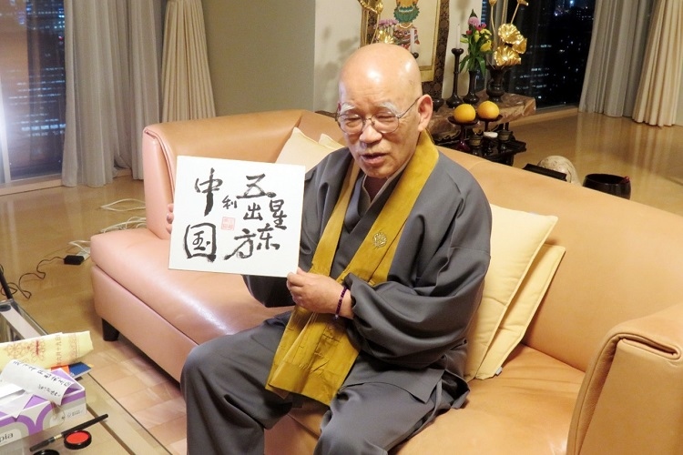 小島康譽(yù)展示自己書(shū)寫(xiě)的“五星出東方利中國(guó)”。視頻截圖