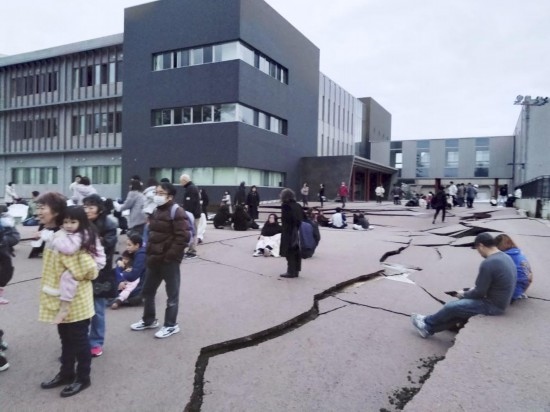  1月1日，在日本石川縣輪島市，人們站在被地震破壞的地面上。新華社/共同社