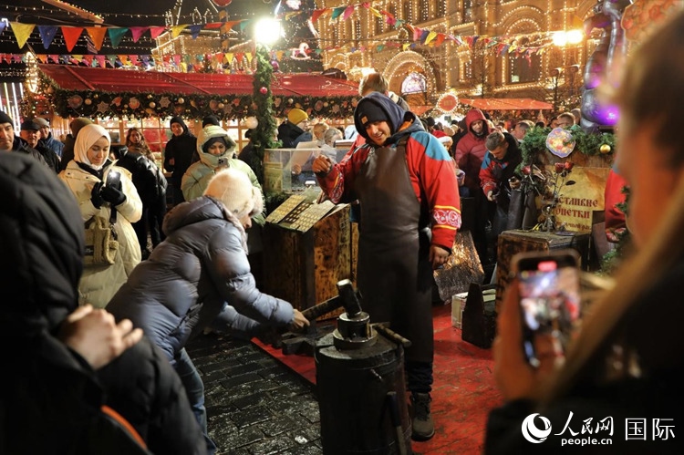 游客在新年集市上體驗(yàn)制作紀(jì)念幣。人民網(wǎng)記者 隋鑫攝