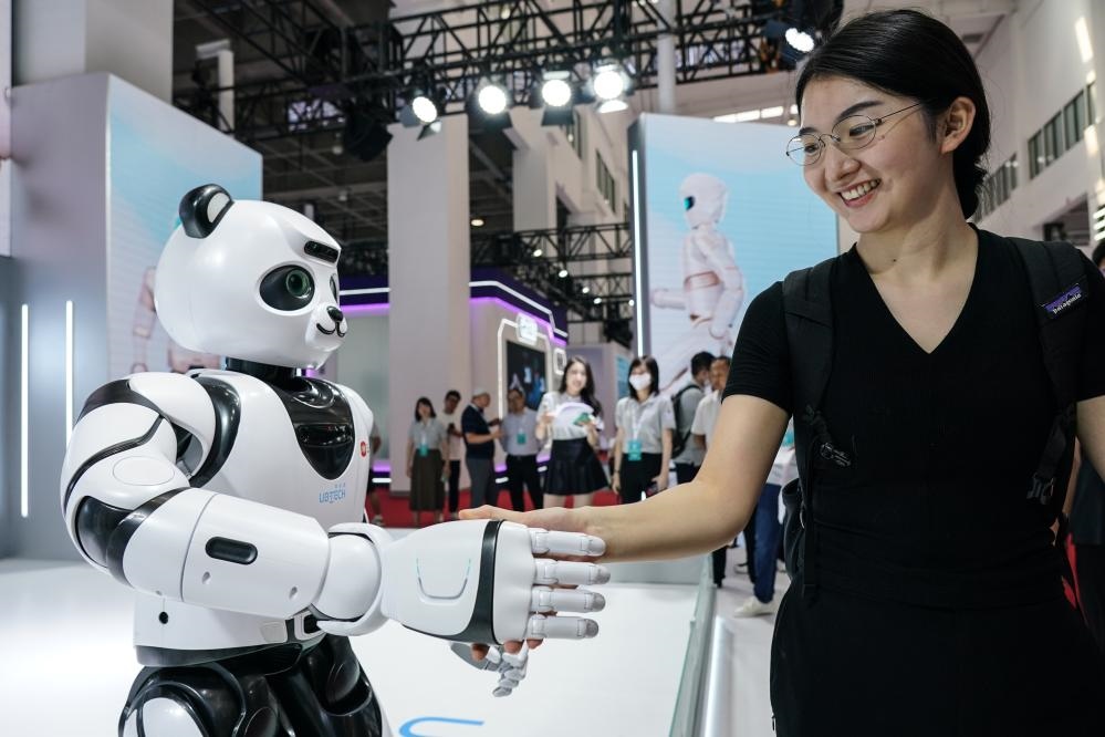 2023年8月16日，一名女士在北京舉辦的2023世界機器人大會現(xiàn)場與智能機器人握手。新華社記者彭子洋攝