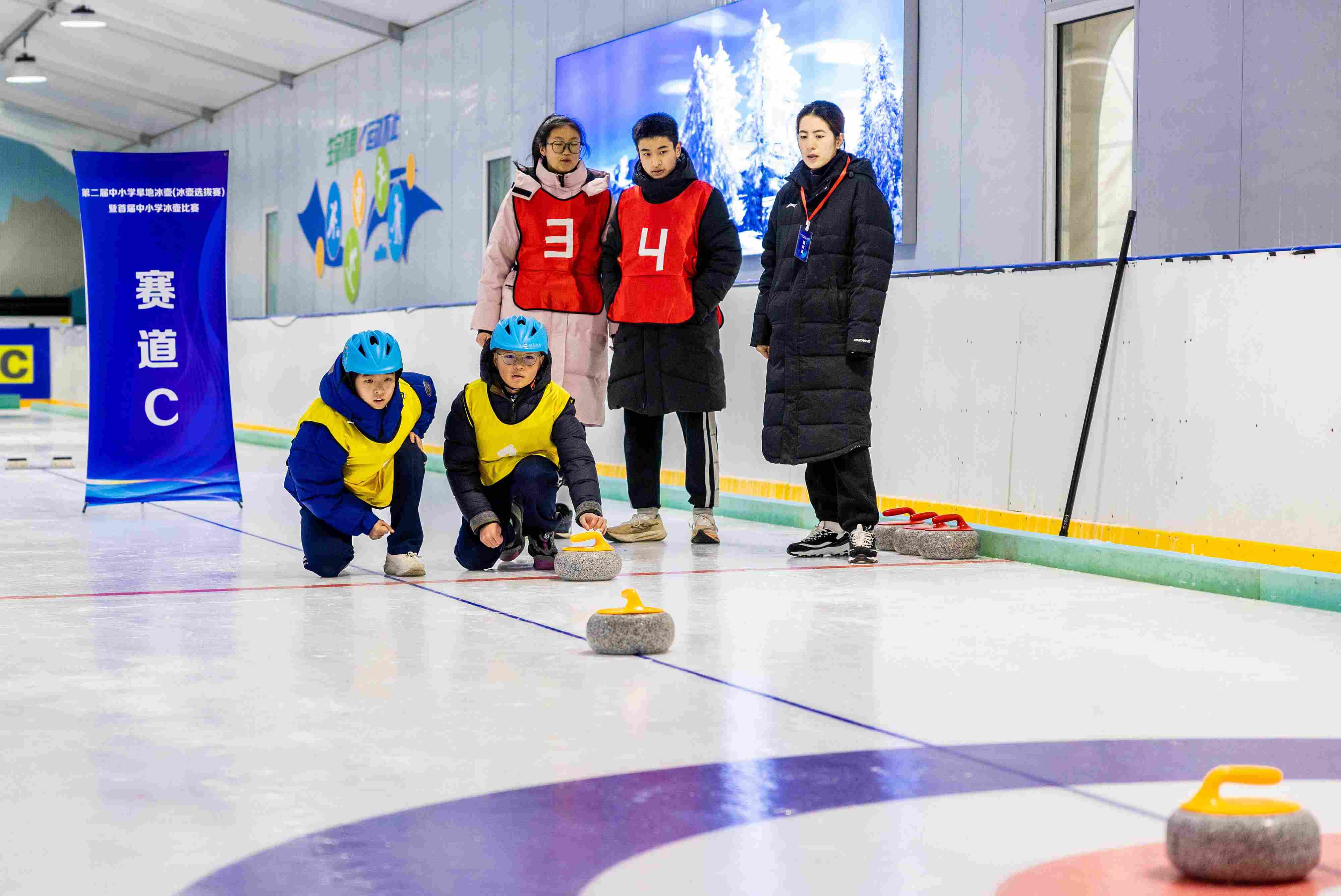 2023年12月10日，參賽選手在呼和浩特首屆中小學(xué)冰壺比賽中投擲冰壺。