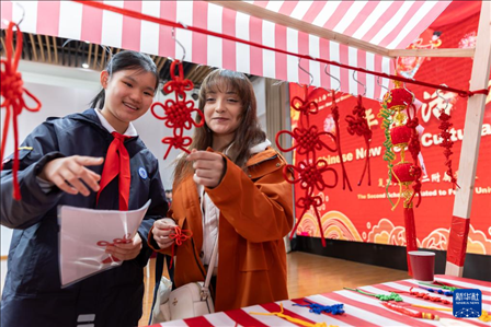 1月28日，復(fù)旦大學(xué)第二附屬學(xué)校學(xué)生（左）為美國馬斯卡廷中學(xué)學(xué)生（右）介紹中國結(jié)。 新華社記者 王翔 攝
