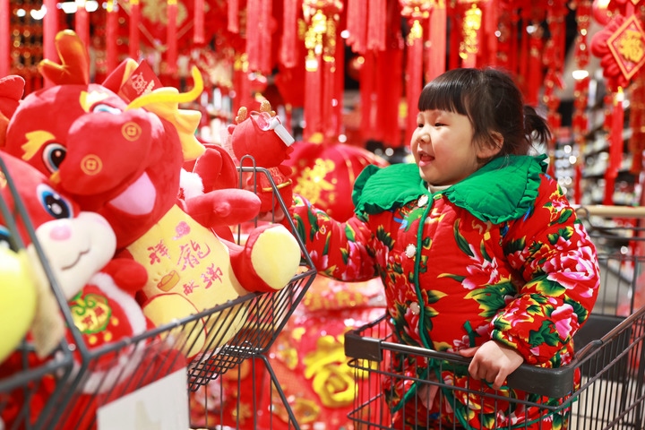 1月23日，在貴州省黔東南苗族侗族自治州岑鞏縣一家超市，小朋友在家人的帶領下選購龍年毛絨玩具。新華社發(fā)（唐鵬攝）