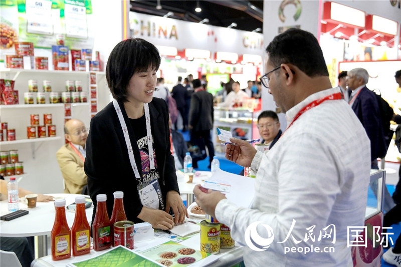 圖為中國參展企業(yè)代表與采購商交流。人民網(wǎng) 塔里克·易卜拉欣攝
