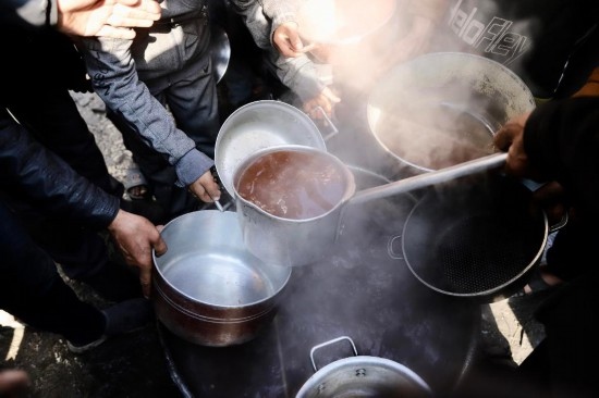  2月27日，在加沙地帶北部的杰巴利耶難民營，人們領(lǐng)取食物。新華社發(fā)（穆罕默德·阿里攝）