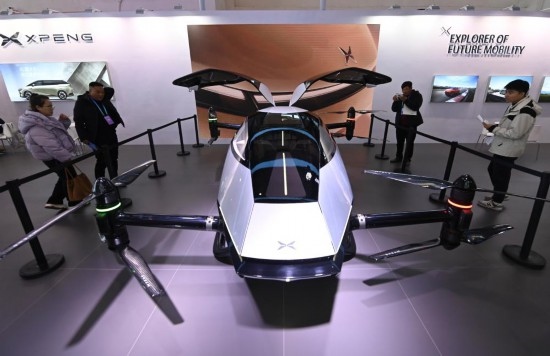 2023年12月1日，在鏈博會智能汽車鏈展區(qū)小鵬汽車展臺，參觀者觀看一臺智能飛行器。新華社記者蔡湘鑫攝