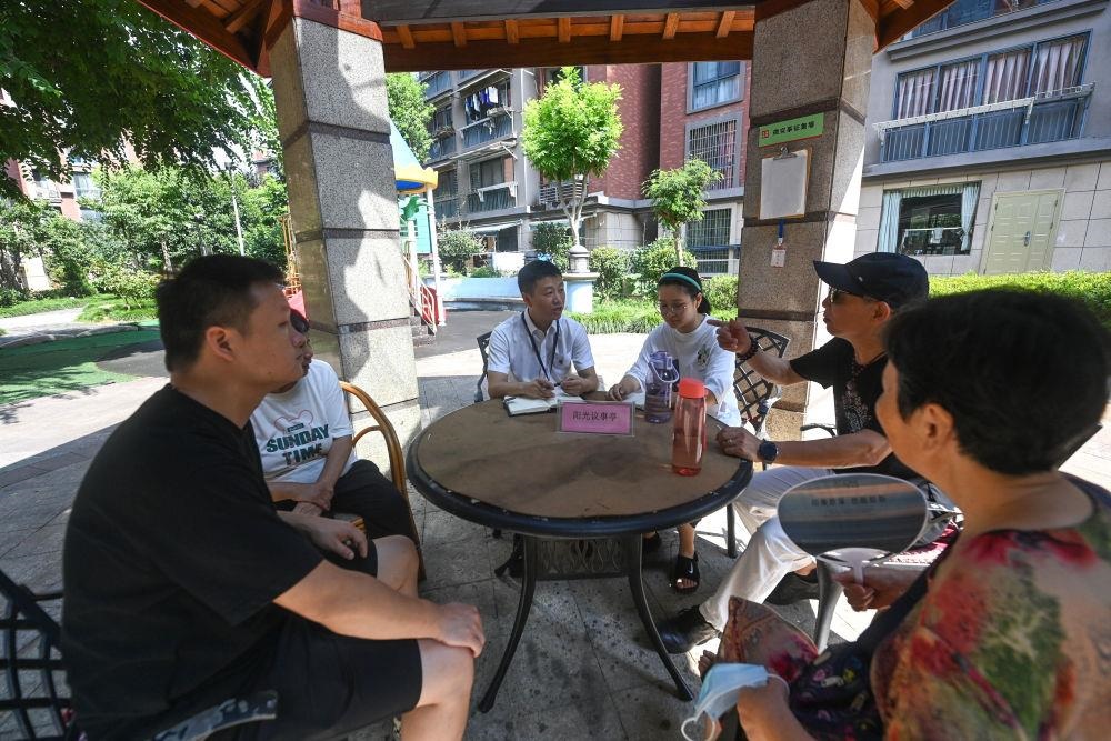 △2023年7月21日，在位于浙江杭州臨安區(qū)錦南街道水岸陽光小區(qū)的陽光議事廳，街道干部在聽取居民們反映的問題及意見。