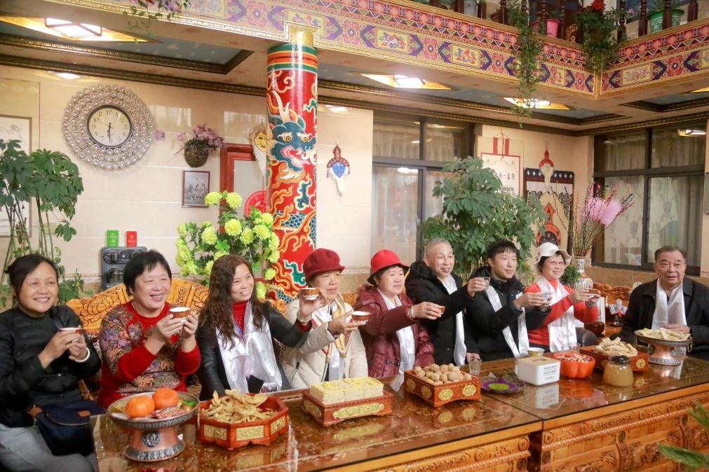 游客們?nèi)胱∶袼藓?，舉杯共飲酥油茶。新華社記者 邱星翔 攝