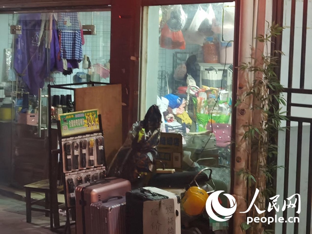 南寧“城中村”一裁縫鋪老板將電線從店內(nèi)拉出為電動自行車充電。人民網(wǎng) 覃心攝