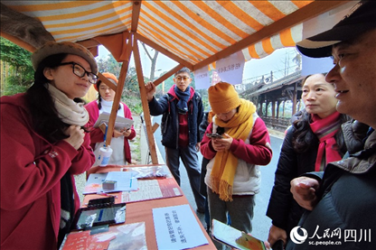 1月6日，“2024成都蒲江柑甜采摘節(jié)”上，記者見到了小萌（左一）和許多年輕人忙著做訪客接待、現(xiàn)場布置、票務核對、采摘服務等工作。人民網(wǎng)記者朱虹攝