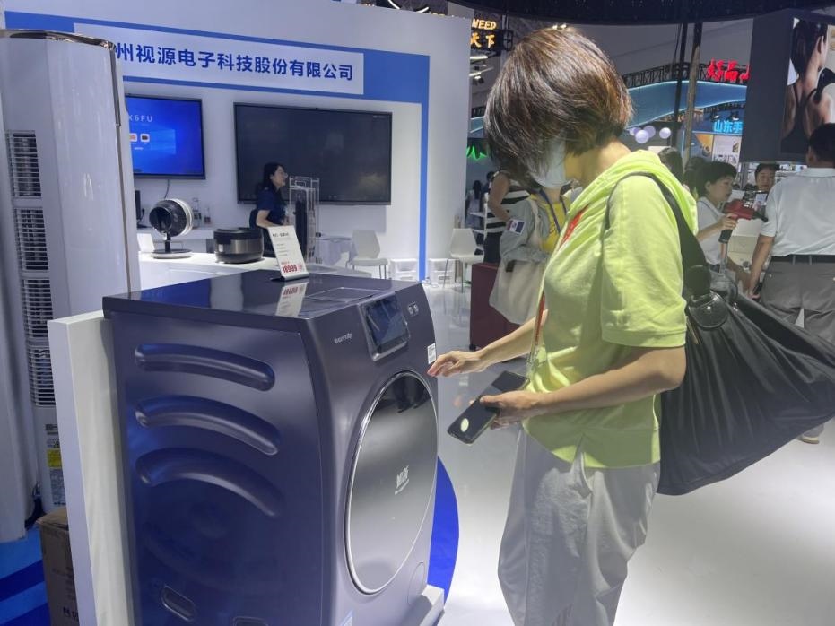 在廣東館展區(qū)內(nèi)，觀展者正在了解家用電器性能。人民網(wǎng)記者 楊迪攝