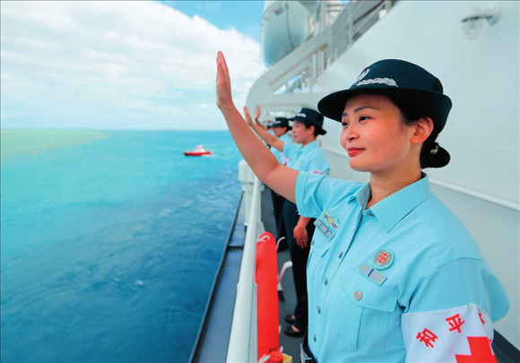 中國(guó)海軍“和平方舟”號(hào)醫(yī)院船結(jié)束訪問(wèn)湯加時(shí)，任務(wù)官兵中的文職人員向歡送人群揮手告別（2023年8月4日攝）。徐巍攝/本刊