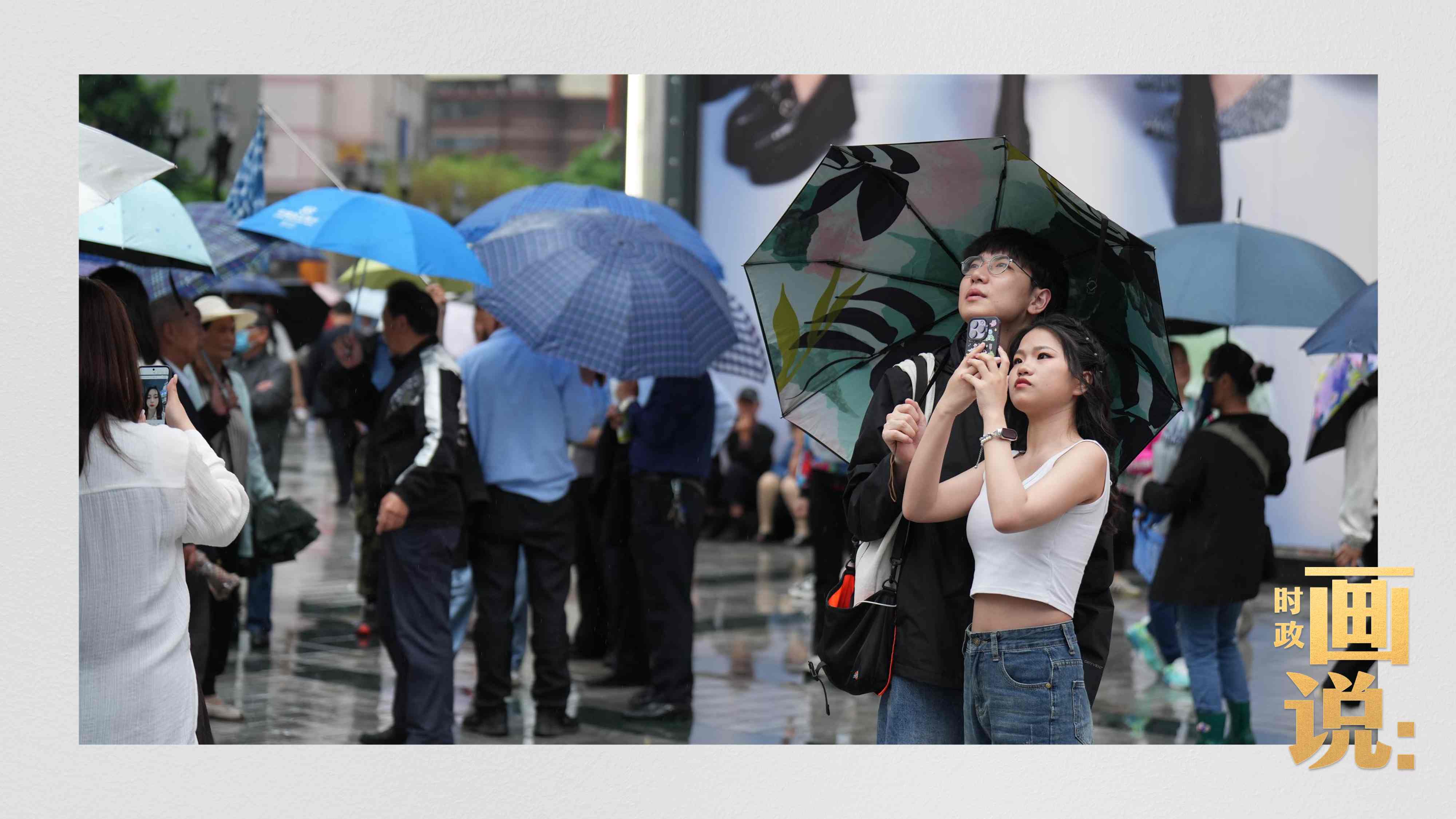 △細雨中的解放碑步行街，騎在父親肩膀的小女孩好奇張望。