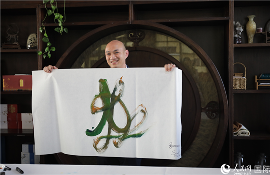 老撾駐華大使館三秘明君參加《五百筆·瀾湄合作》集體藝術(shù)創(chuàng)作。人民網(wǎng)王婧攝。