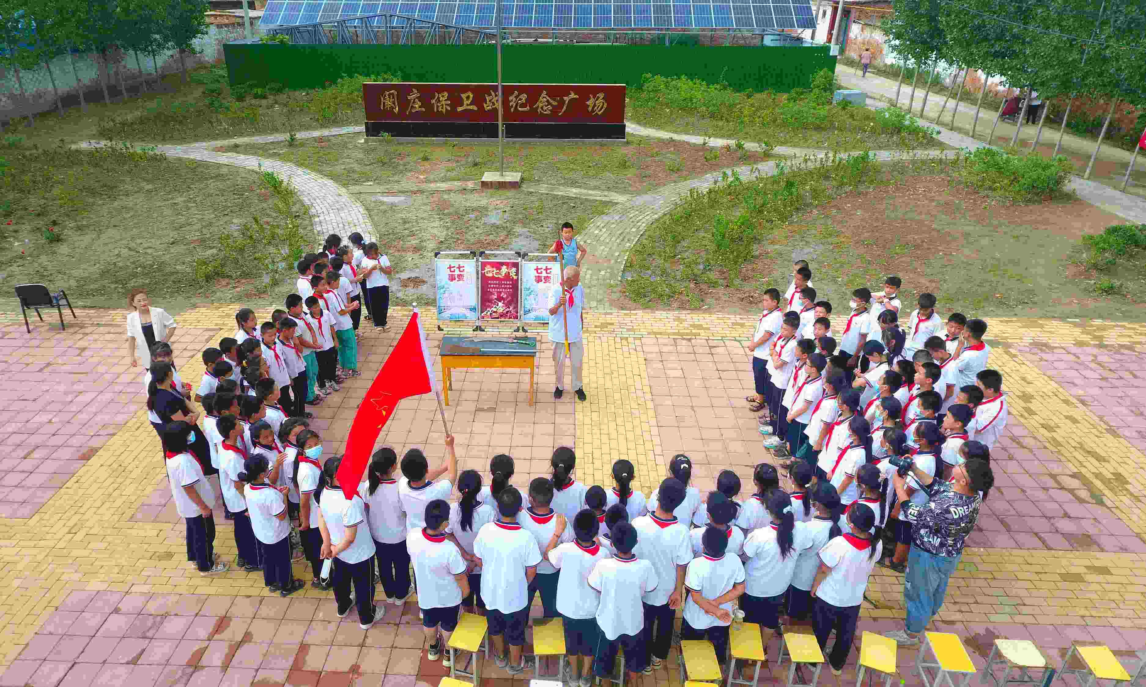 2022年7月6日，山東省聊城市，在茌平區(qū)菜屯鎮(zhèn)闞莊村的闞莊保衛(wèi)戰(zhàn)紀念廣場，闞莊保衛(wèi)戰(zhàn)親歷者王光木老人為小學生們講述抗戰(zhàn)故事，展示大刀、長矛。