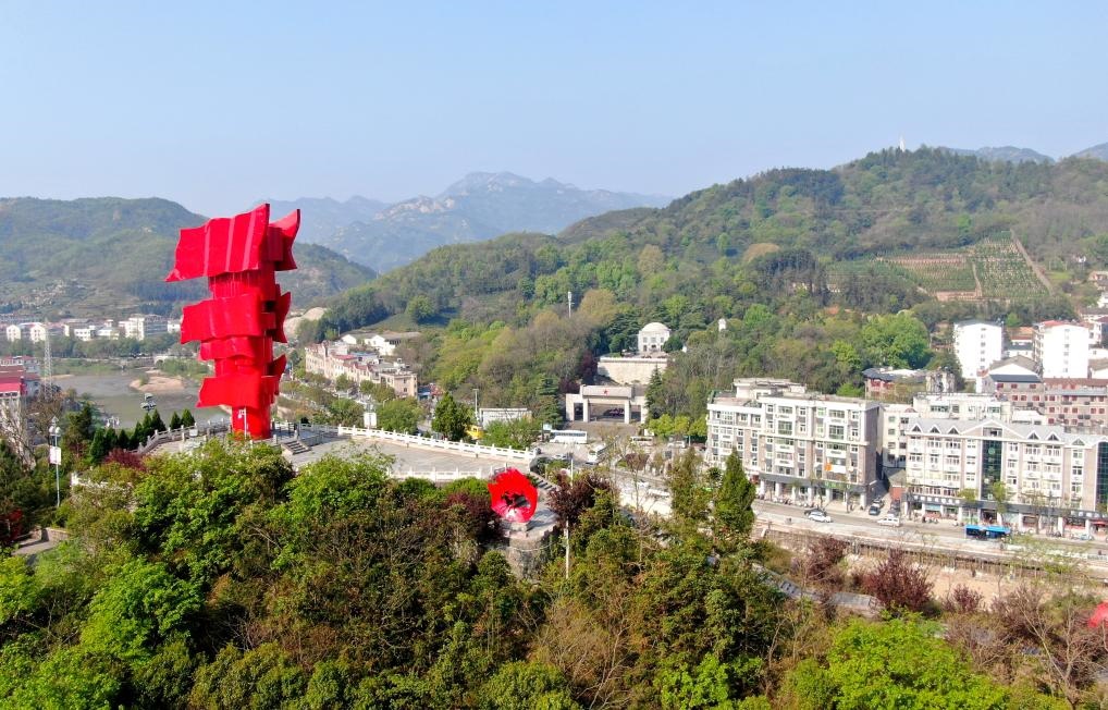 這是2021年4月9日拍攝的鄂豫皖蘇區(qū)首府革命博物館附近的英雄山上的“紅旗飄飄”主題雕塑（無人機(jī)照片）。新華社發(fā)