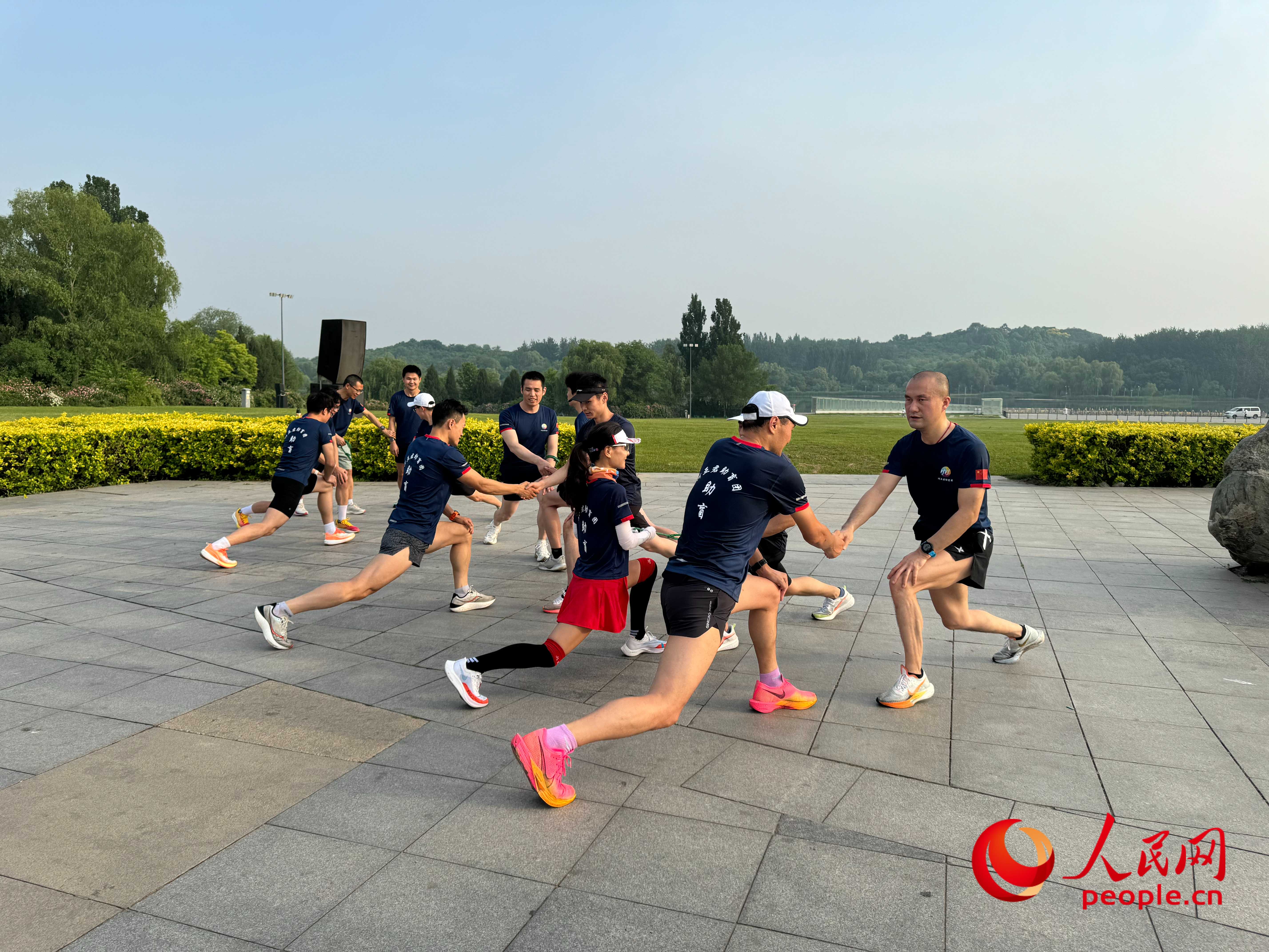 盲人和志愿者做跑步前準(zhǔn)備。人民網(wǎng) 周靜圓攝