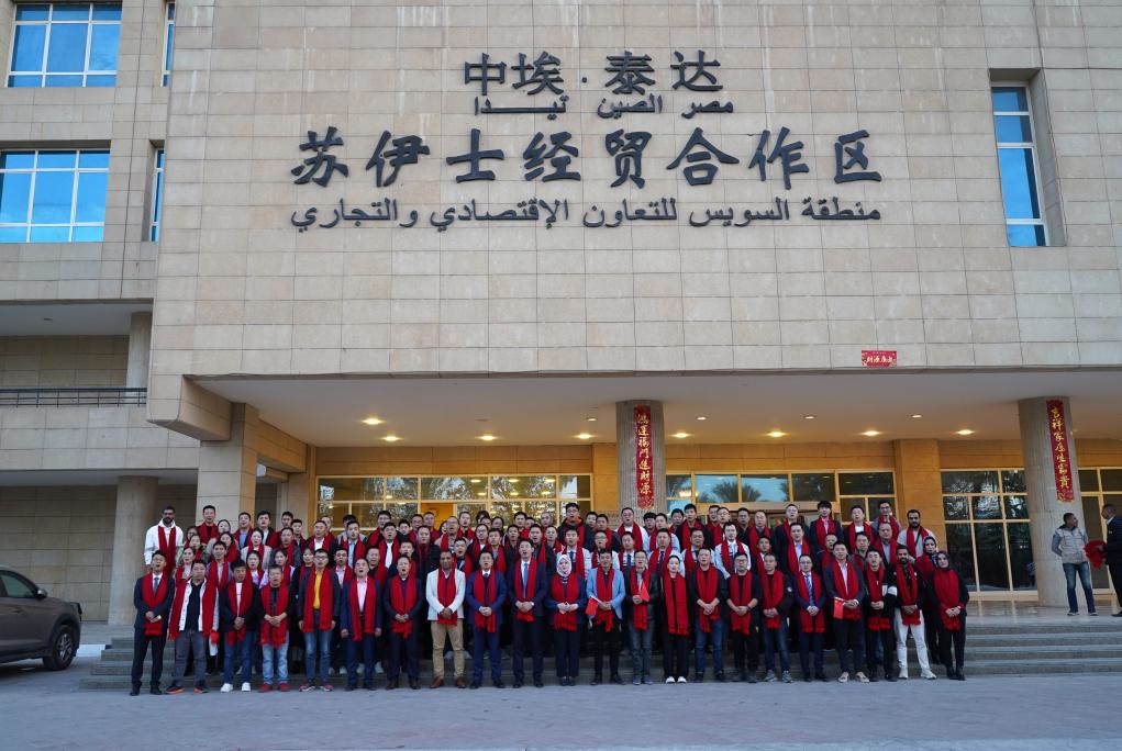 2024年2月11日，在位于埃及蘇伊士省的中?！ぬ┻_(dá)蘇伊士經(jīng)貿(mào)合作區(qū)，中埃員工在合作區(qū)辦公大樓前合影拜年。新華社發(fā)（泰達(dá)合作區(qū)供圖）