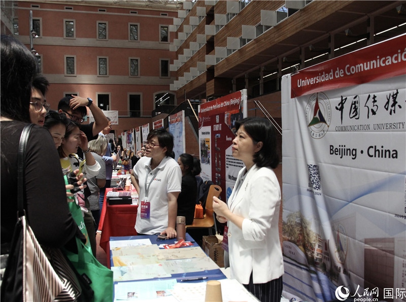 旅西華人華僑在展臺前咨詢。人民網(wǎng)記者 許海林?jǐn)z