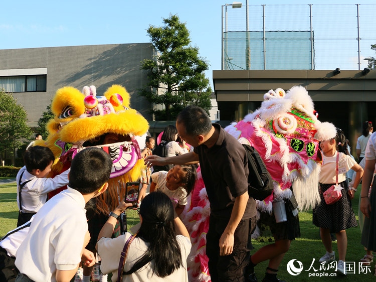 孩子們好奇地圍觀舞獅。人民網(wǎng) 許可攝