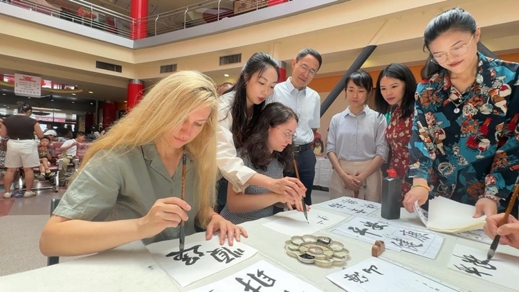 羅馬尼亞友人在活動現(xiàn)場學(xué)寫漢字。中國駐羅馬尼亞大使館領(lǐng)僑處供圖