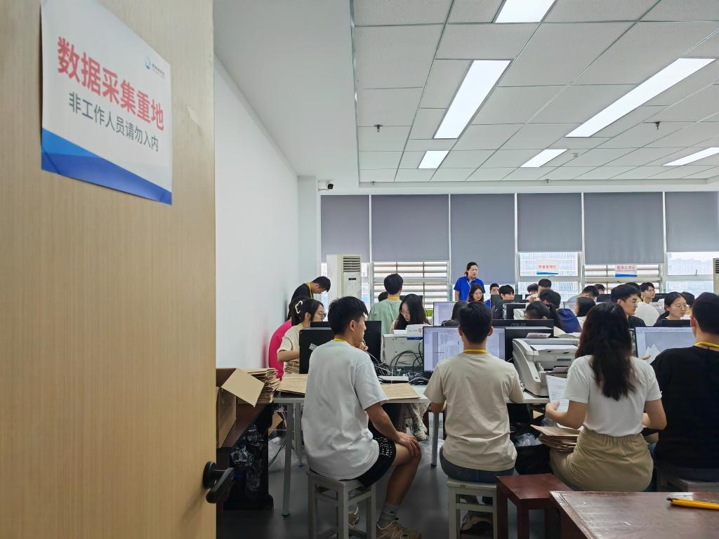 6月13日，在重慶市西南大學(xué)評卷點(diǎn)，工作人員正在進(jìn)行試卷掃描工作。新華社記者 周思宇 攝