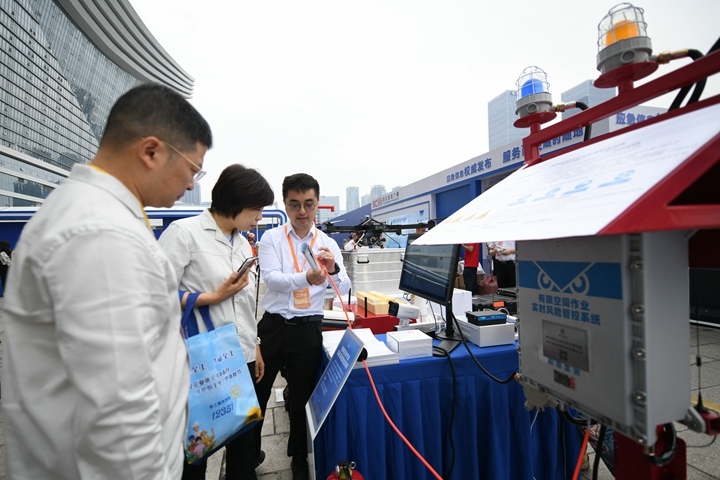 6月16日，在全國“安全宣傳咨詢?nèi)铡敝鲌龌顒?dòng)上，四川省安全科學(xué)技術(shù)研究院工作人員（右一）向參觀者介紹“有限空間作業(yè)實(shí)時(shí)風(fēng)險(xiǎn)管控系統(tǒng)”。新華社記者胥冰潔攝