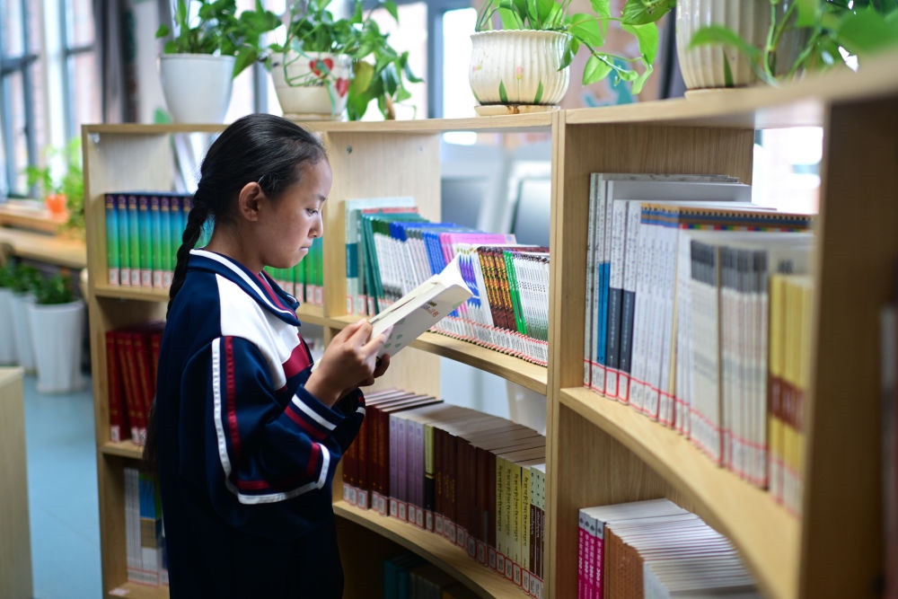 6月18日，果洛西寧民族中學(xué)學(xué)生尼東拉毛在圖書室看書。