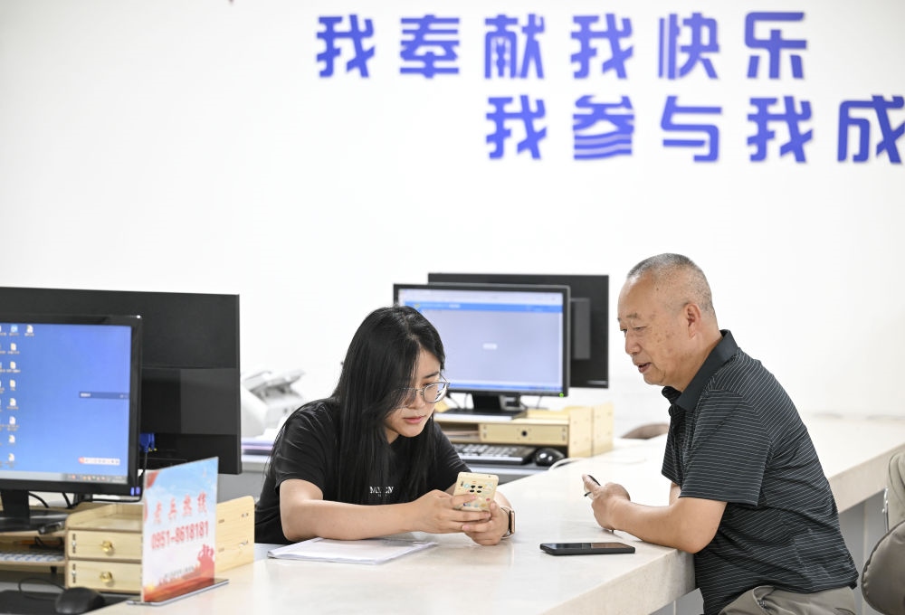 6月20日，在長(zhǎng)城花園社區(qū)黨群服務(wù)中心，工作人員幫助居民辦理業(yè)務(wù)。