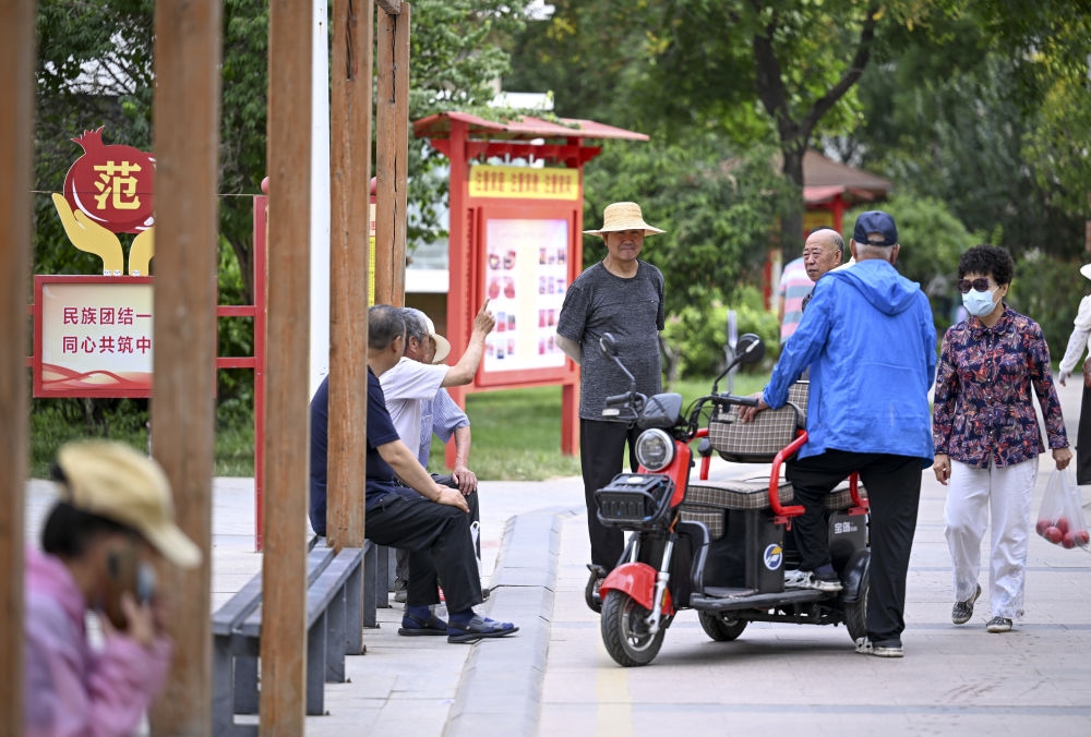 6月20日，長(zhǎng)城花園社區(qū)的居民在休閑、聊天。