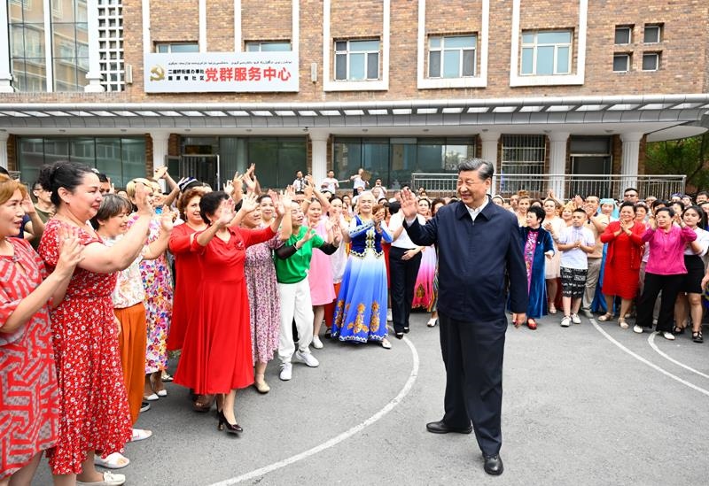 2022年7月13日，習(xí)近平總書記在新疆烏魯木齊市天山區(qū)固原巷社區(qū)考察時，向各族群眾揮手致意。