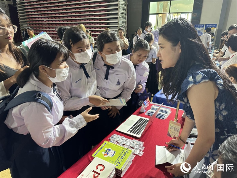 來自泰國的學生、家長在教育展臺前咨詢。人民網(wǎng)記者 簡承淵攝