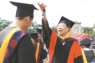 2017年6月22日，李德仁（右一）參加武漢大學(xué)畢業(yè)典禮并為畢業(yè)生撥穗。