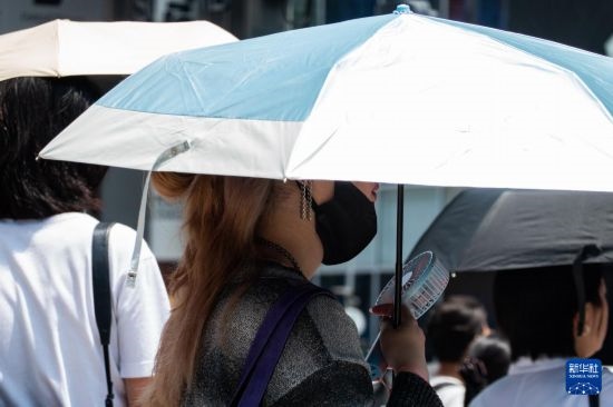 7月4日，人們?cè)谌毡緰|京原宿的街道上等待紅綠燈。新華社記者 張笑宇 攝