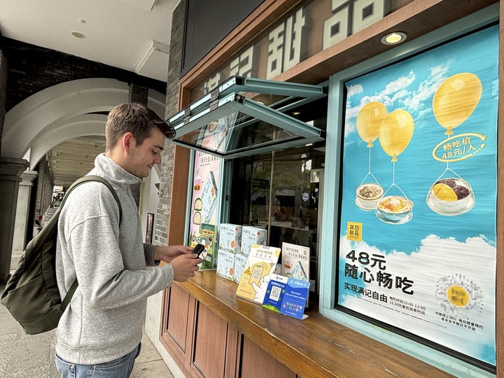 來自德國的留學生理查德在杭州西湖邊一家商鋪使用支付寶掃碼支付（2024年4月11日攝）。新華社發(fā)