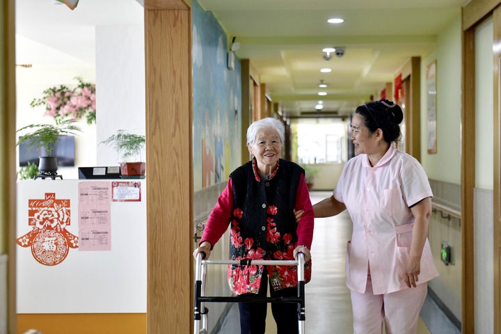 2024年5月25日，在山東省日照市東港區(qū)石臼街道日照幸福護(hù)理院，工作人員在陪護(hù)老人。新華社記者 郭緒雷 攝
