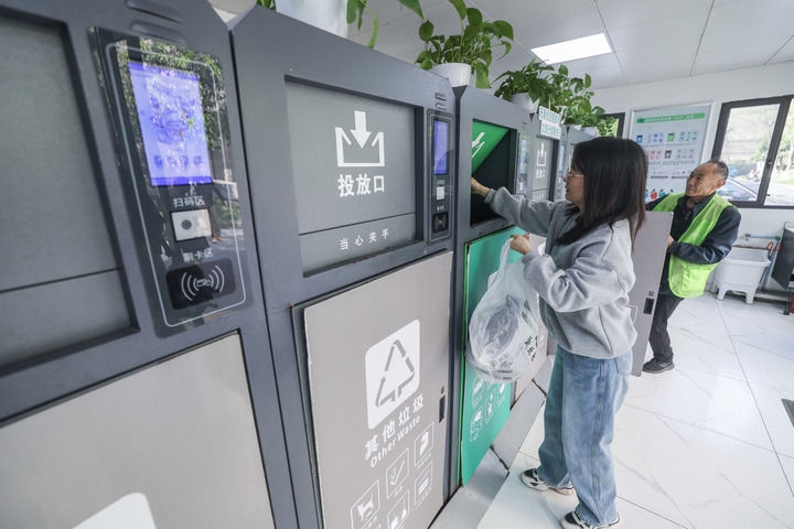 2024年4月10日，在浙江省湖州市吳興區(qū)飛英街道新華府小區(qū)內(nèi)，居民在垃圾分類智能系統(tǒng)的指導(dǎo)下進(jìn)行垃圾分類投放，居民的投放情況將實(shí)時匯總到智慧服務(wù)平臺，會有相應(yīng)的積分獎勵。新華社記者 徐昱 攝