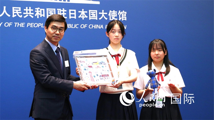 日本小大使向中國駐日本大使館臨時代辦施泳贈送當?shù)靥厣Y品。人民網(wǎng) 許可攝