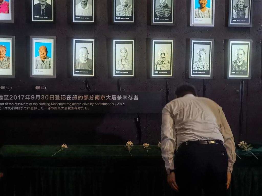 7月18日，人們向離世的南京大屠殺幸存者獻花、鞠躬。新華社記者邱冰清 攝