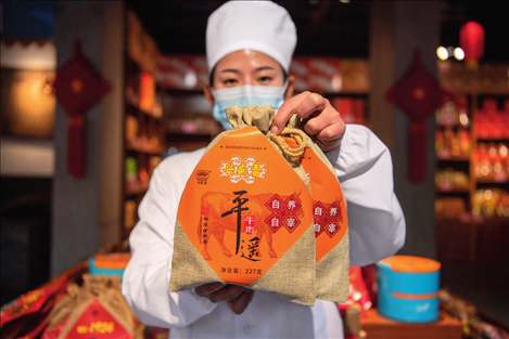 在位于山西省晉中市平遙縣的平遙古城南大街的一家平遙牛肉店內(nèi)，工作人員展示一款牛肉產(chǎn)品（資料照片）楊晨光攝 / 本刊