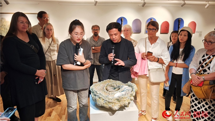 參展人、景德鎮(zhèn)陶瓷大學設計藝術學院副院長余劍峰（中）向來賓介紹參展作品。人民網記者 殷淼攝