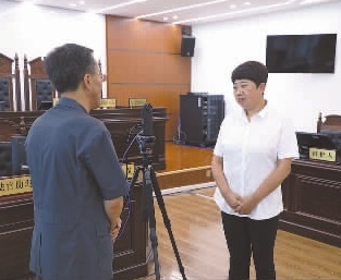 圖為全國人大代表玉明姬（右）詳細(xì)了解環(huán)境資源審判工作情況。劉思妤 攝