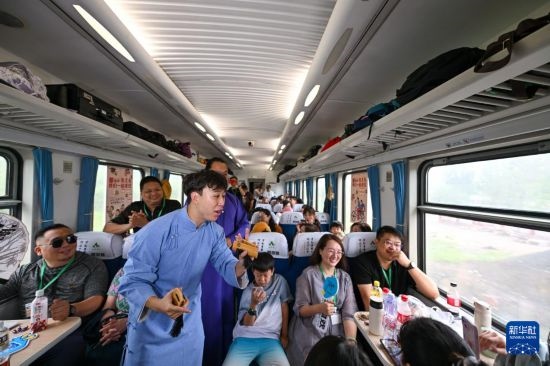 9月7日，相聲演員在S910列車上為旅客表演快板。