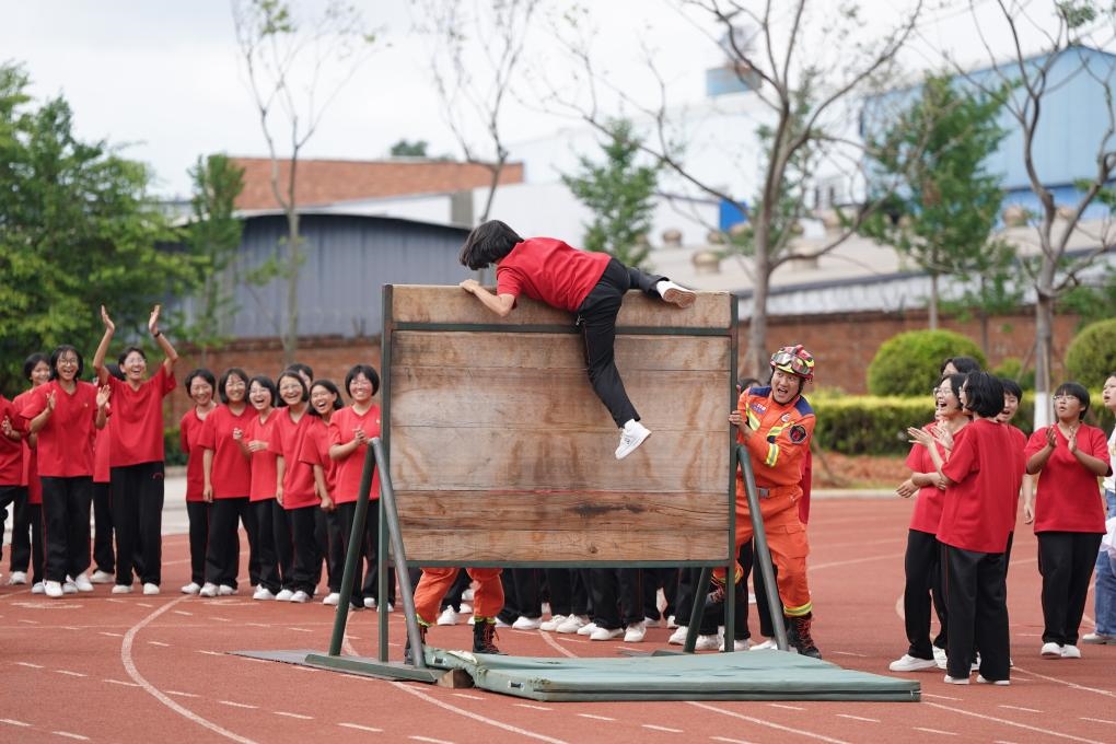云南麗江華坪女子高級(jí)中學(xué)學(xué)生在體驗(yàn)翻越障礙板。新華社記者陳欣波 攝
